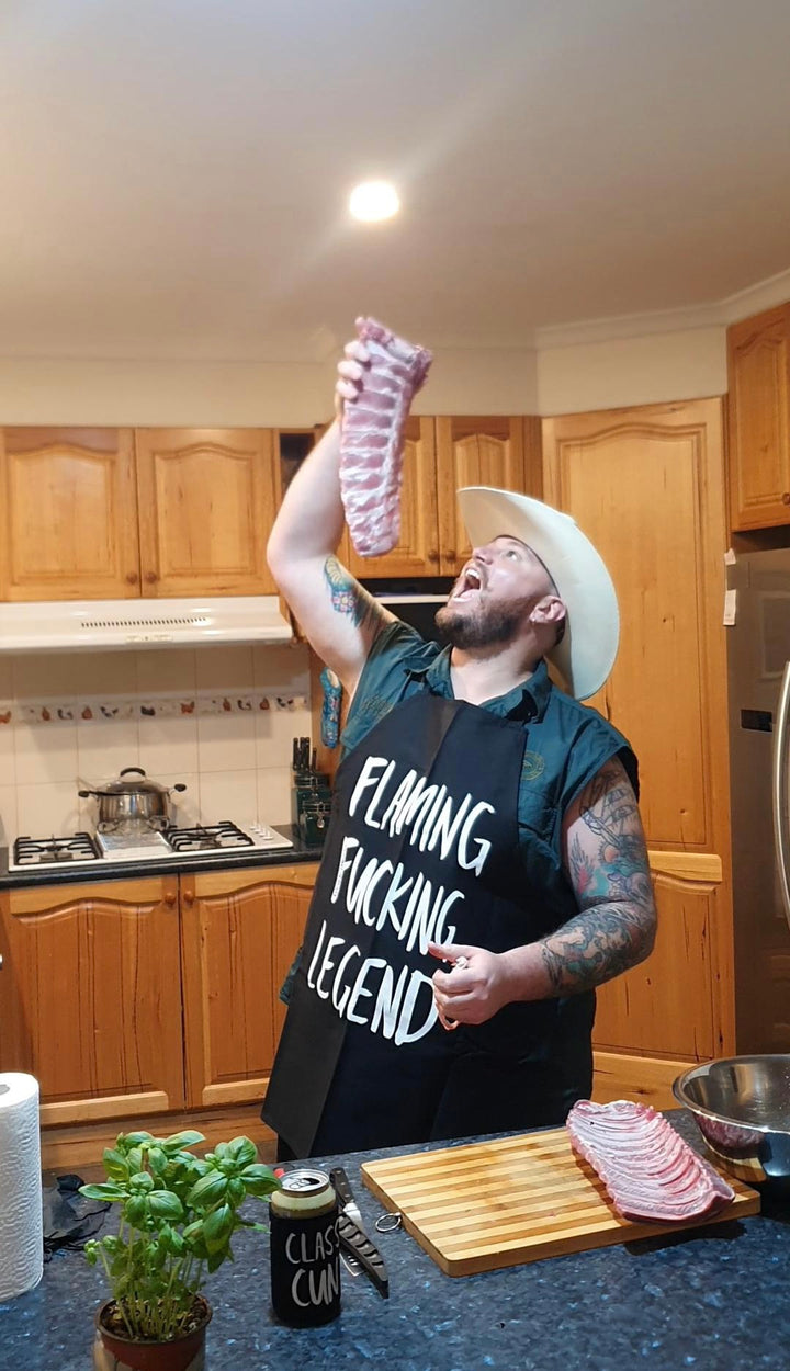 A flaming fucking legend wearing our Flaming Fucking Legend apron in the kitchen