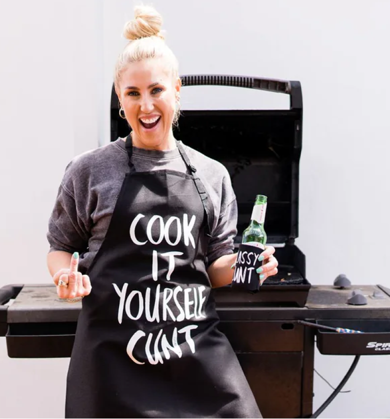 Cheeky chick wearing Cook It Yourself Cunt apron